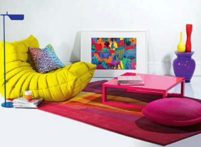El color de fúcsia a la catifa es repeteix en la tapisseria de l’otomà i el colorant de la taula