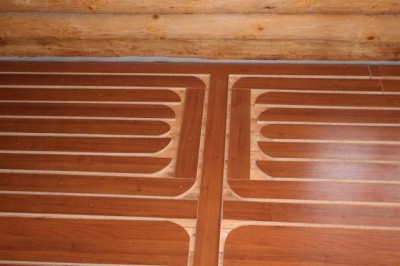 Is it possible to install a floor heating system under a laminate on an old wooden floor?