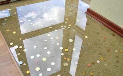 Monedas debajo de un piso de poliuretano transparente