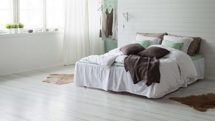 Dormitorio con lapinado blanco en el piso y las paredes.