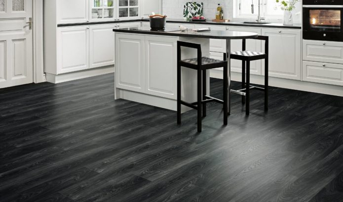 Didelės baltos virtuvės interjeras su juodomis grindimis