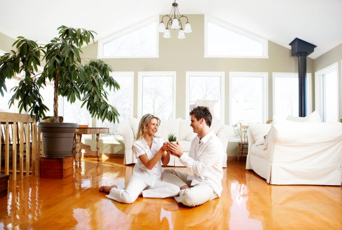 Vyras ir moteris baltais drabužiais sėdi ant grindų.