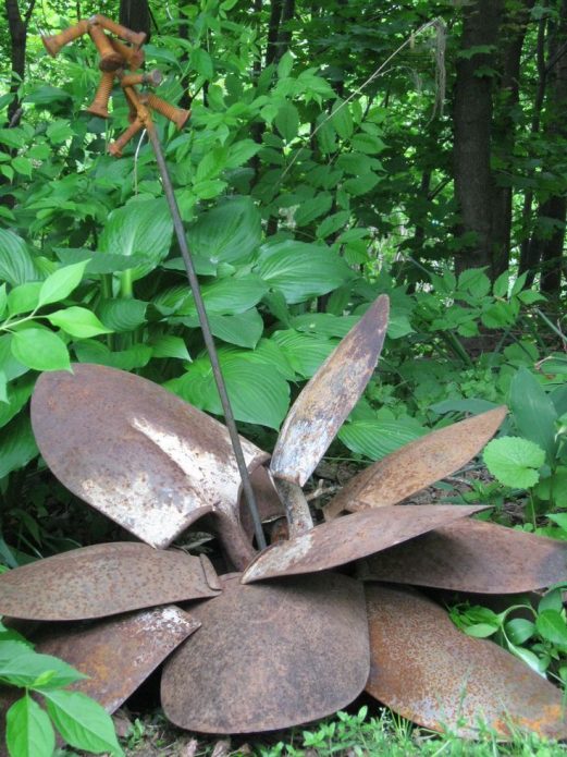 Decoration of a garden flower bed from old shovels