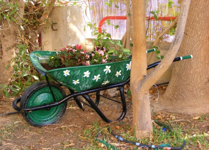 Цветна цветна леха върху градинска количка