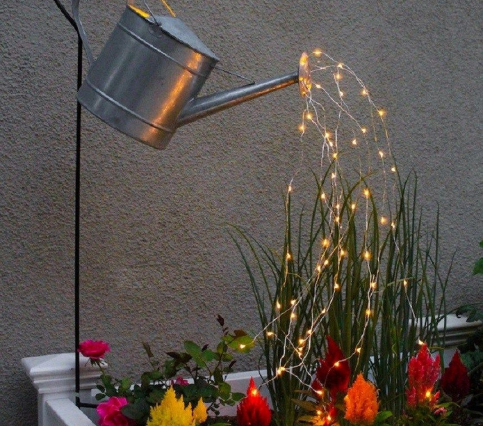 En farverig lampe over et blomsterbed fra en vandkande