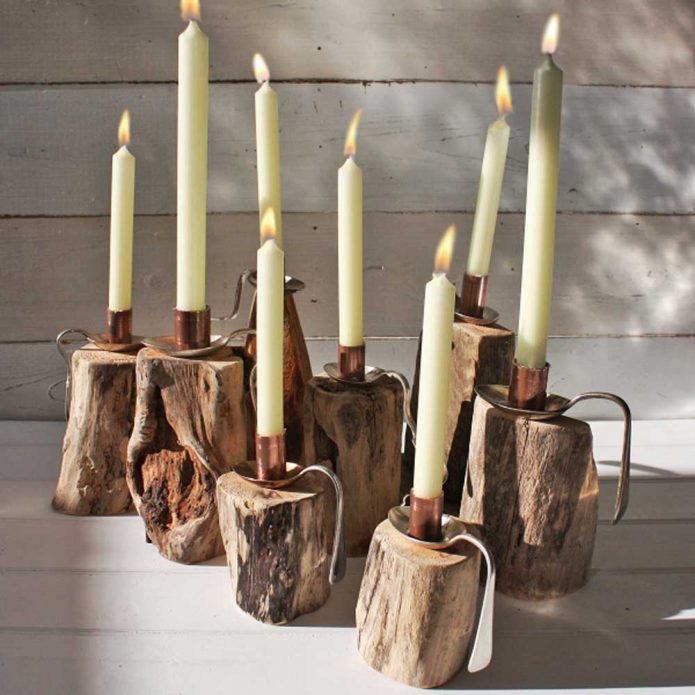 Tall candles on a stand made of wood and spoons
