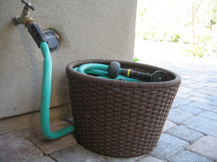 Ang pag-iimbak ng isang hose ng hardin sa isang basket