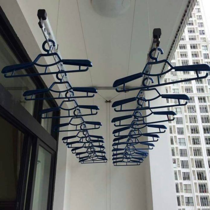 Patuyo sa balkonahe ng mga metal rods at hanger ng coat