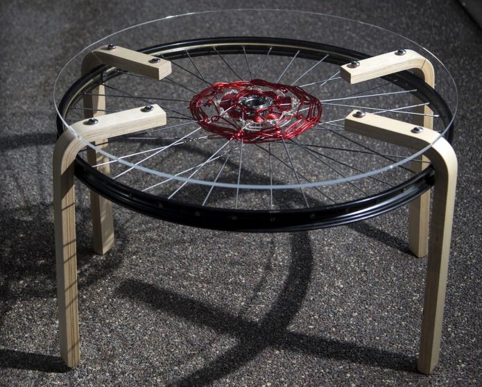 Mazs no riteņiem izgatavots galds uz koka kājām