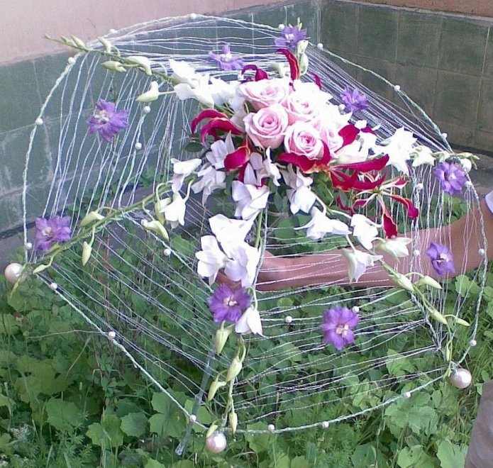 Decoração de um canteiro de flores com uma composição de guarda-chuva e flores