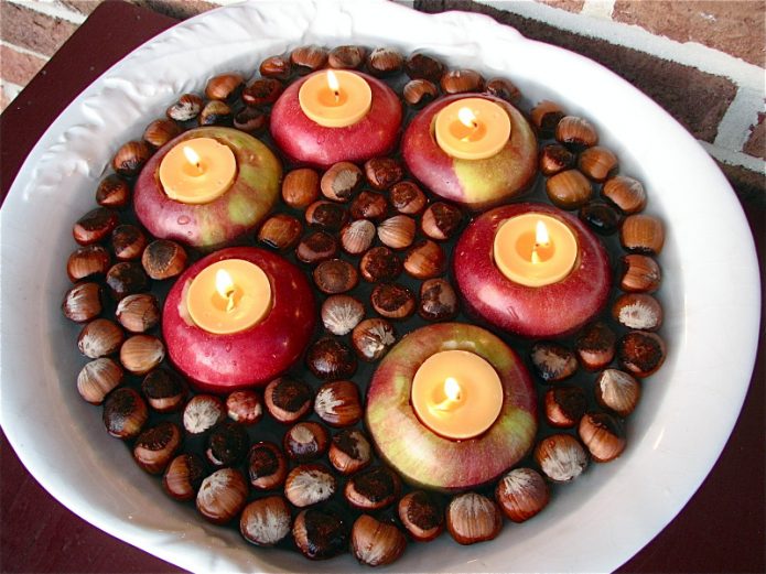 Sammansättning av nötter och äpplen med stearinljus