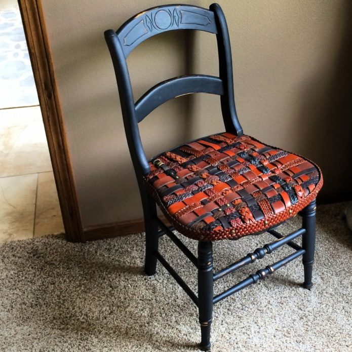 Vecs krēsls, kas dekorēts ar siksnām