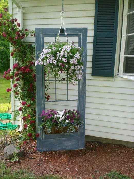 Behållare blomsterrabatt av en gammal dörr