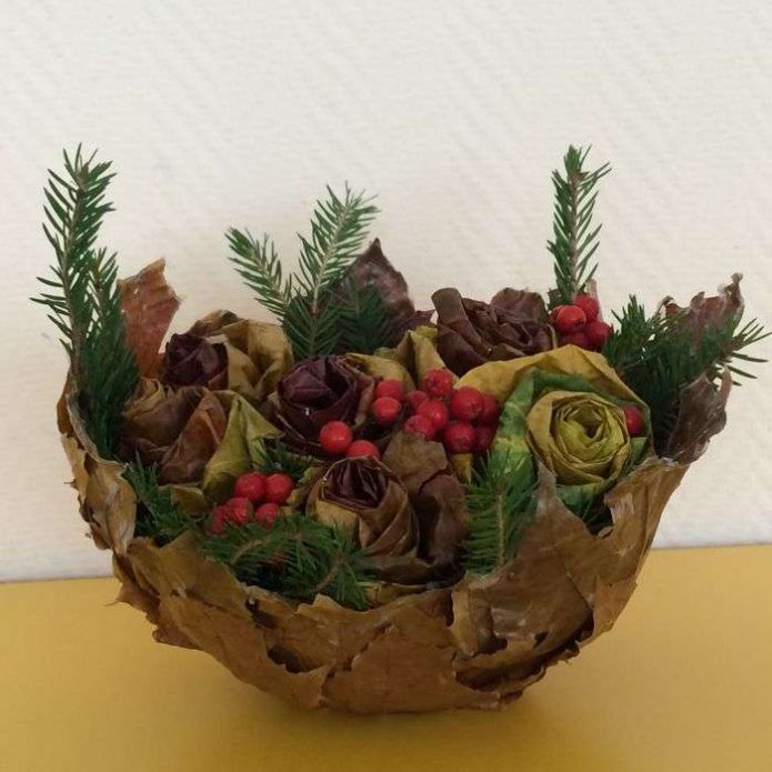 A dish of leaves with cones and flowers
