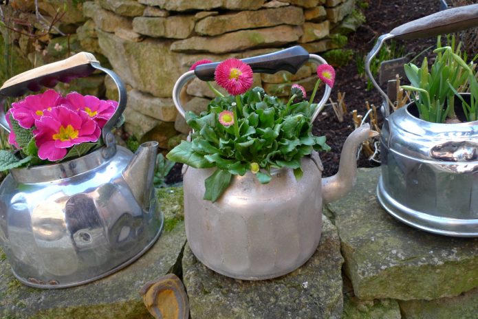 Blomsterbed af gamle tepotter